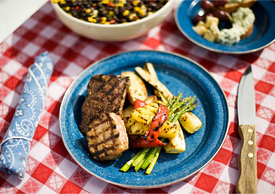 Plate of meat and vegetables on a picnic table
