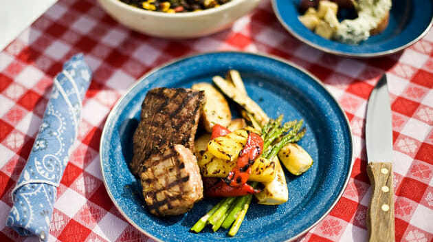 Plate of meat and vegetables on a picnic table