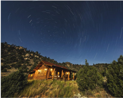 Cabin at dusk with stars in the dark blue sky