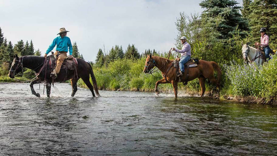 Horseback riding through a river at 4UR Ranch