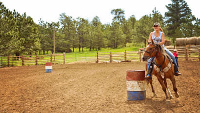 Woman riding in the barrel arena at Cherokee Park Ranch