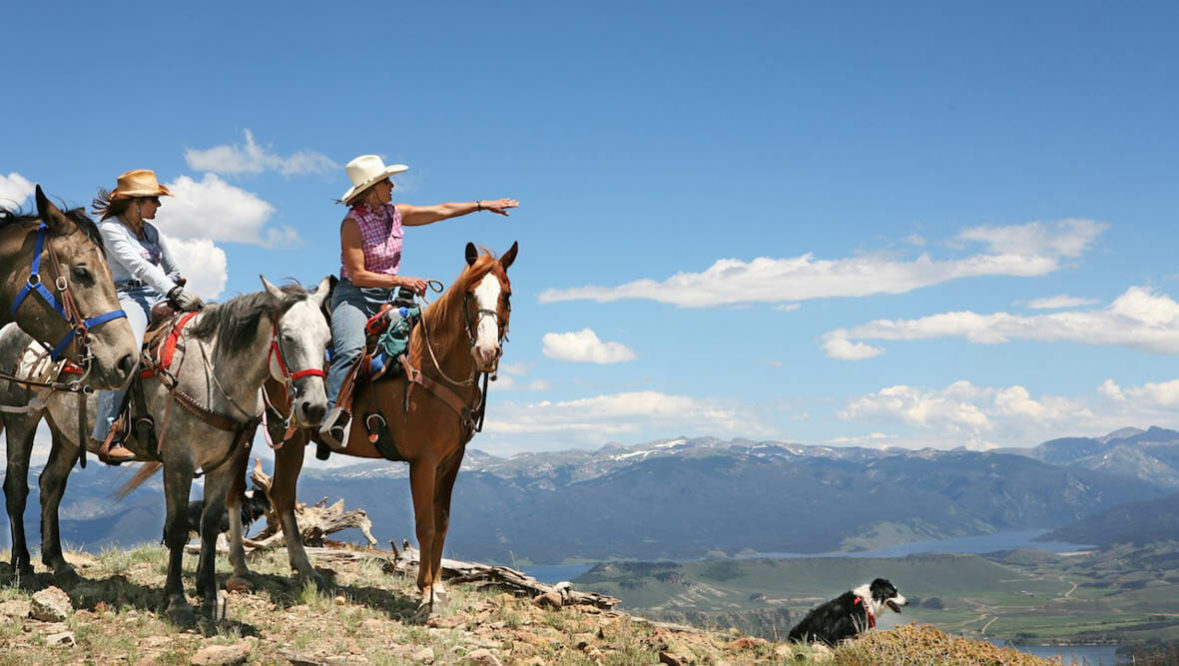 Woman on horse pointing at Drowsy Water Ranch