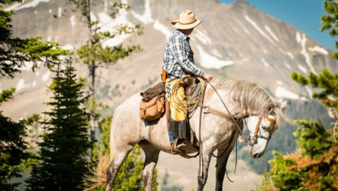 Cowboy near a mountain at Lone Mountain Ranch