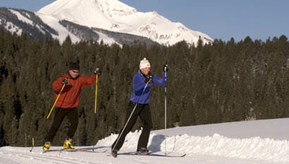 Two guests cross country skiing at Lone Mountain Ranch