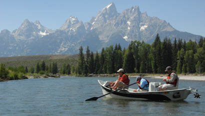 Two people in a boat fishing on a lake at Triangle X Ranch