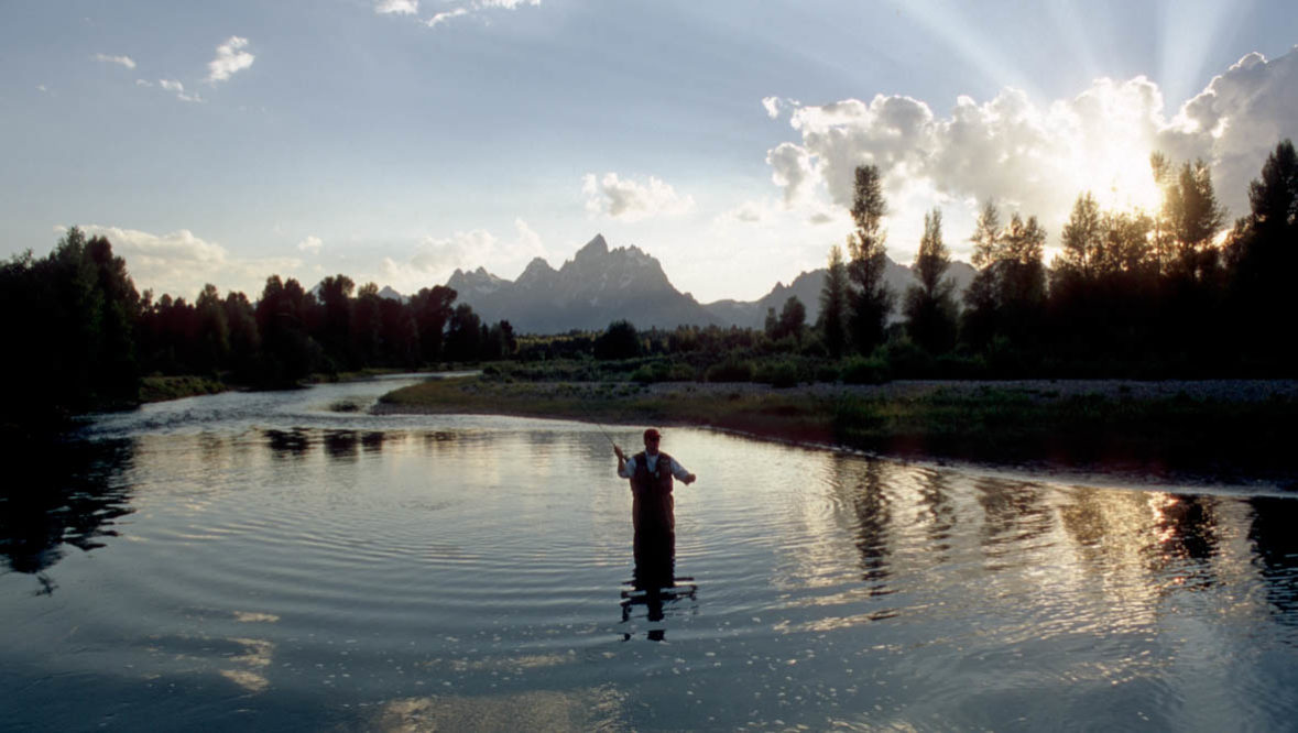 Man fishing in a lake at Triangle X Ranch