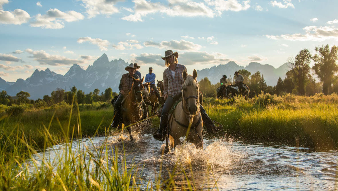 Riders and Horses crossing a river at Triangle X Ranch