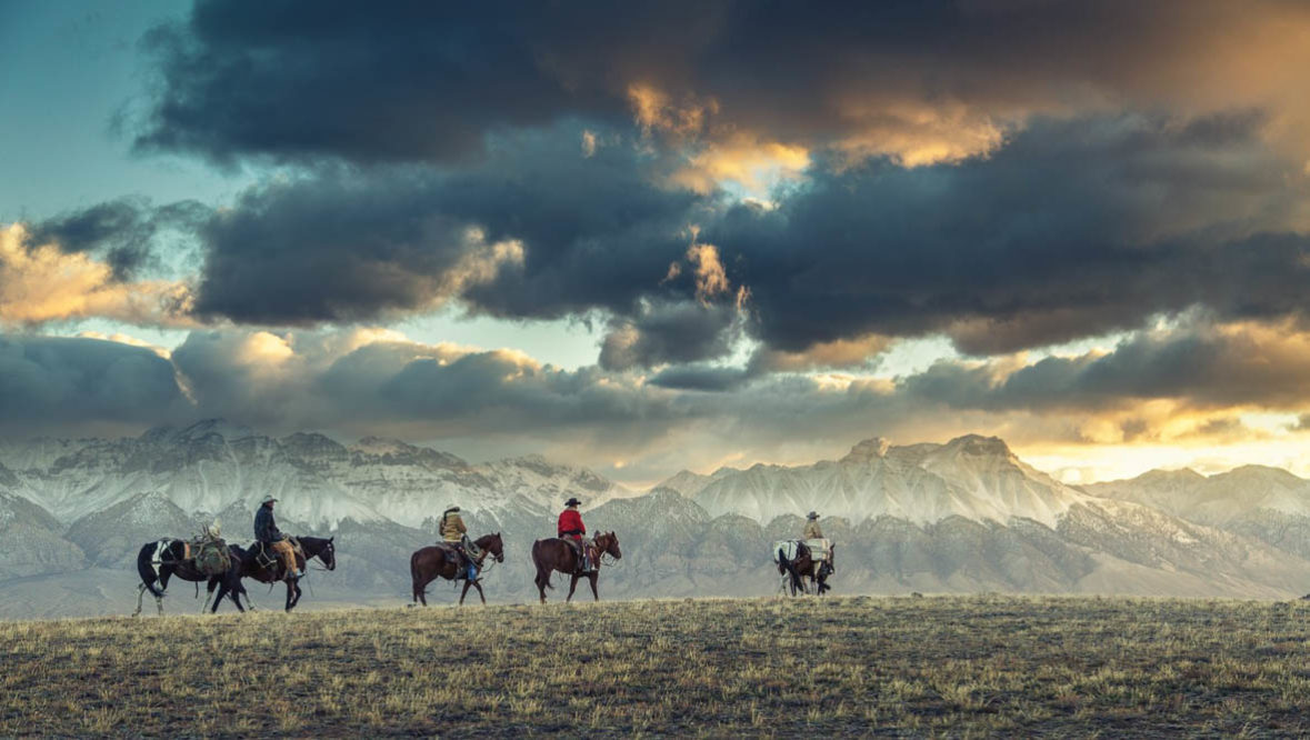 Trail ride across a prairie at Vee Bar Ranch