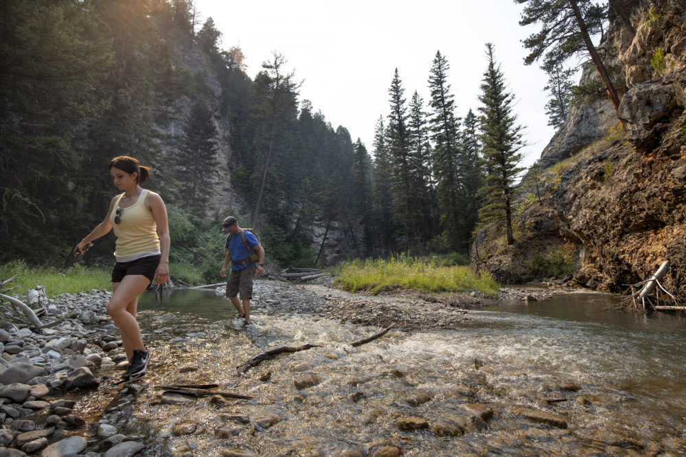 guests walking across a creek at Circle Bar Ranch