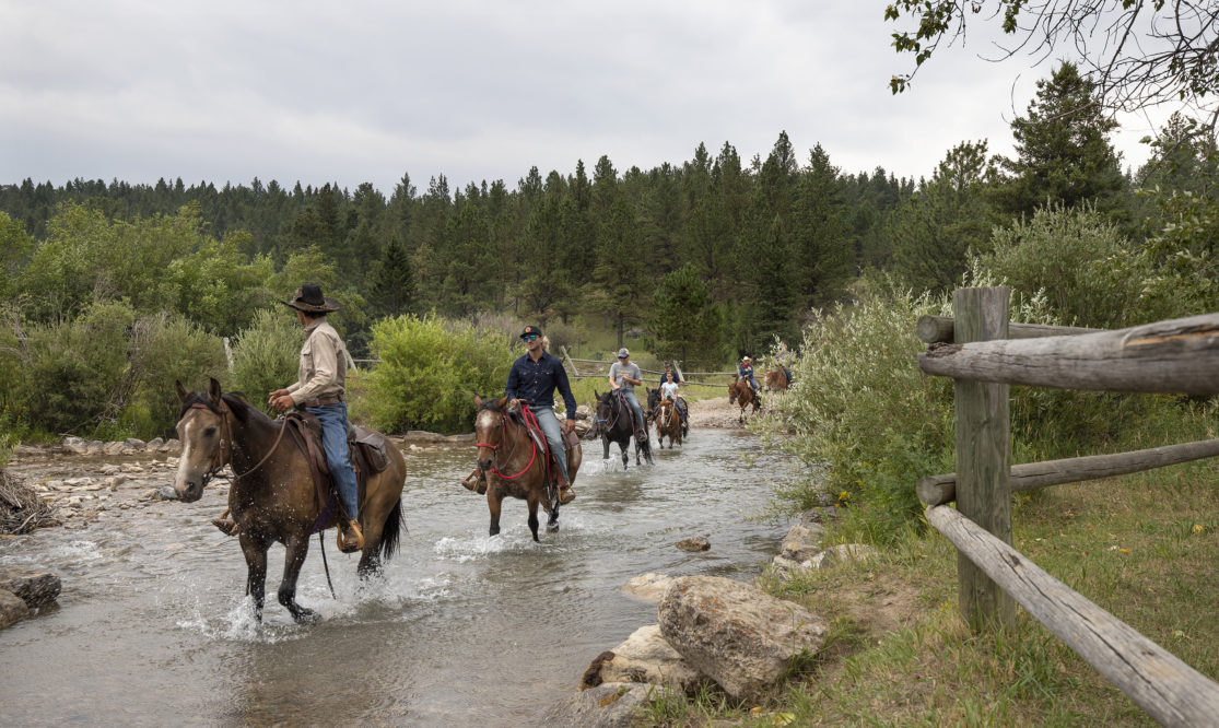 guest on a trail ride in a river at Circle Bar Ranch