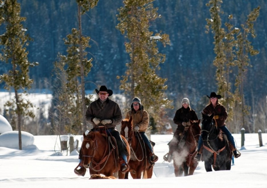 riding horses through snow at Vista Verde Ranch